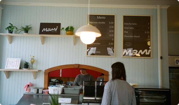 Comptoir du Mami Café, avec le tableau du menu et une suspension lumineuse.
