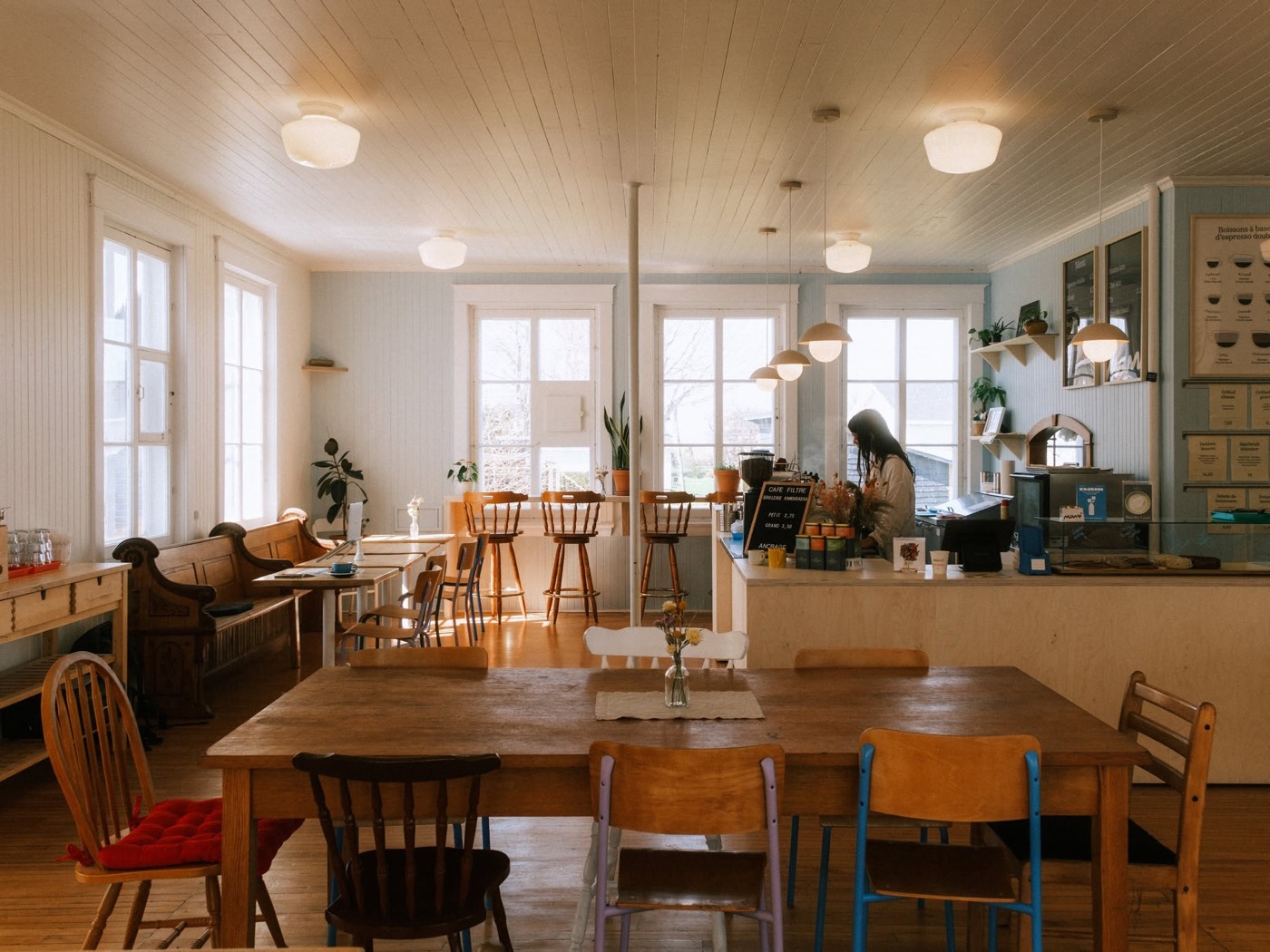 Deux femmes assises à une table dans le café, discutant avec la ville en arrière-plan.